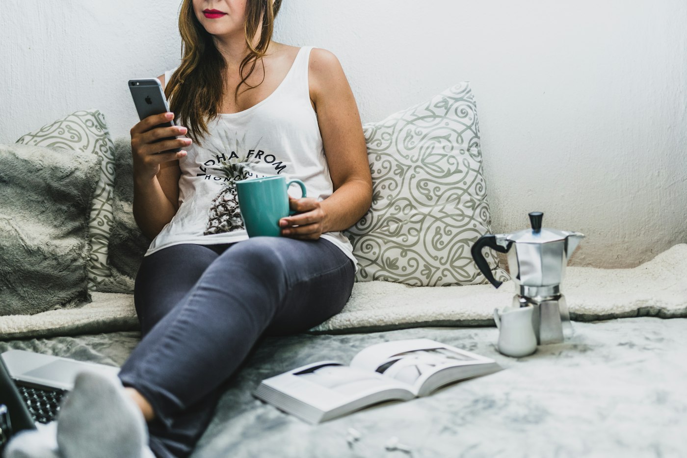 A reader at home with a phone and coffee
